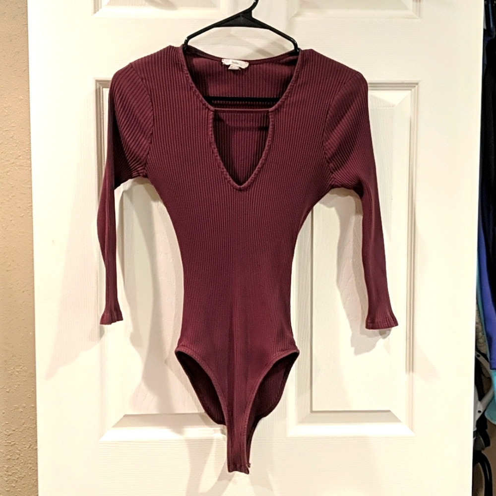 Plum colored, ribbed bodysuit with deep V neck